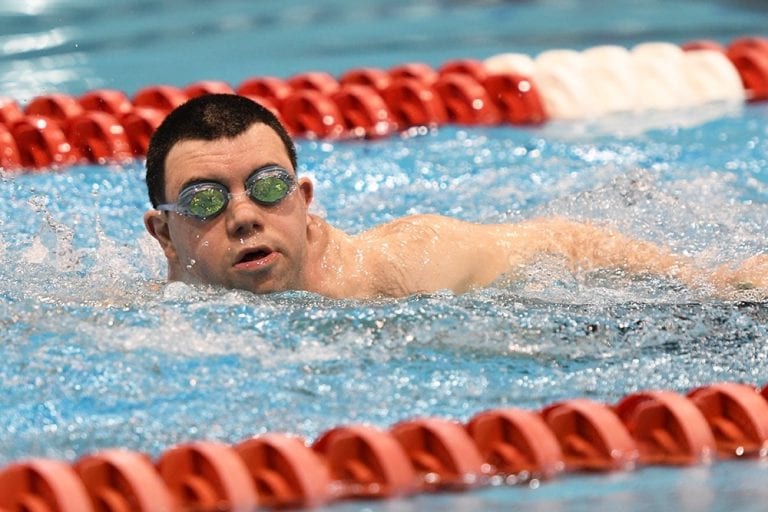 Special Olympian swimming in the pool.