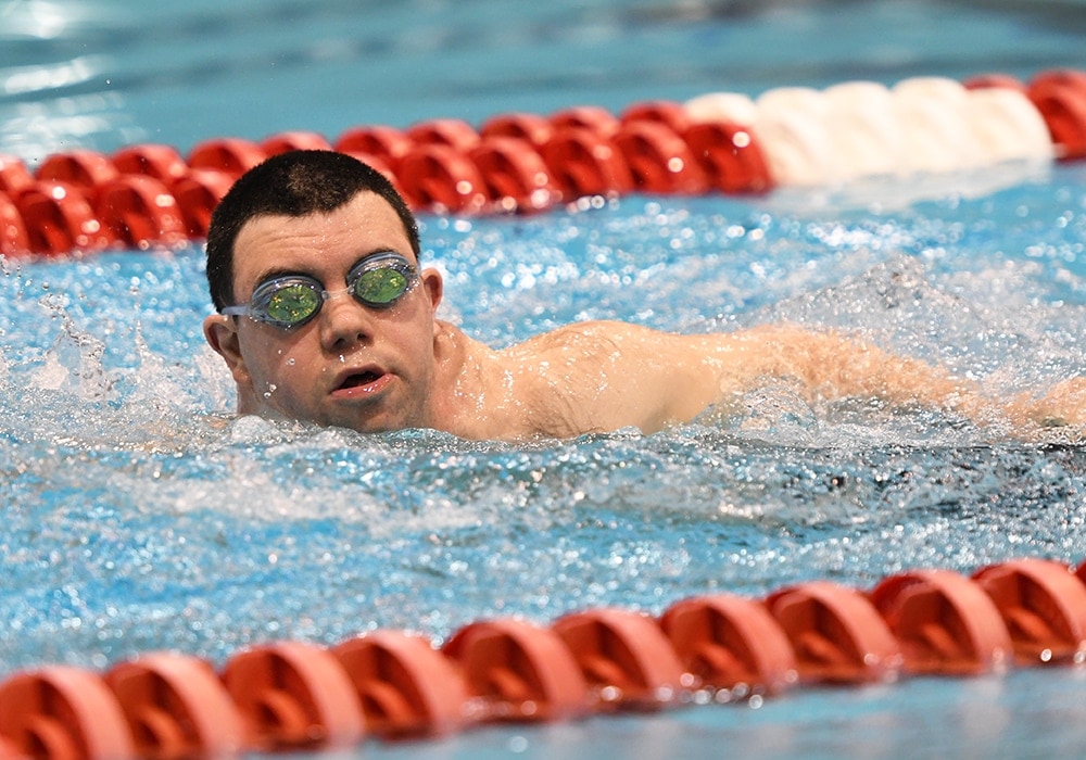 Special Olympian swimming in the pool.