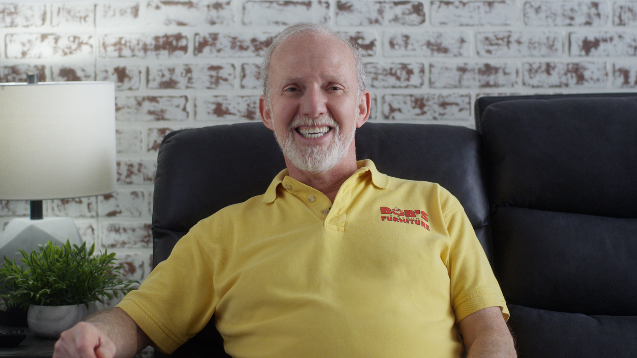 Bob Kaufman, the founder of Bob's Discount Furniture, sits on a sofa.