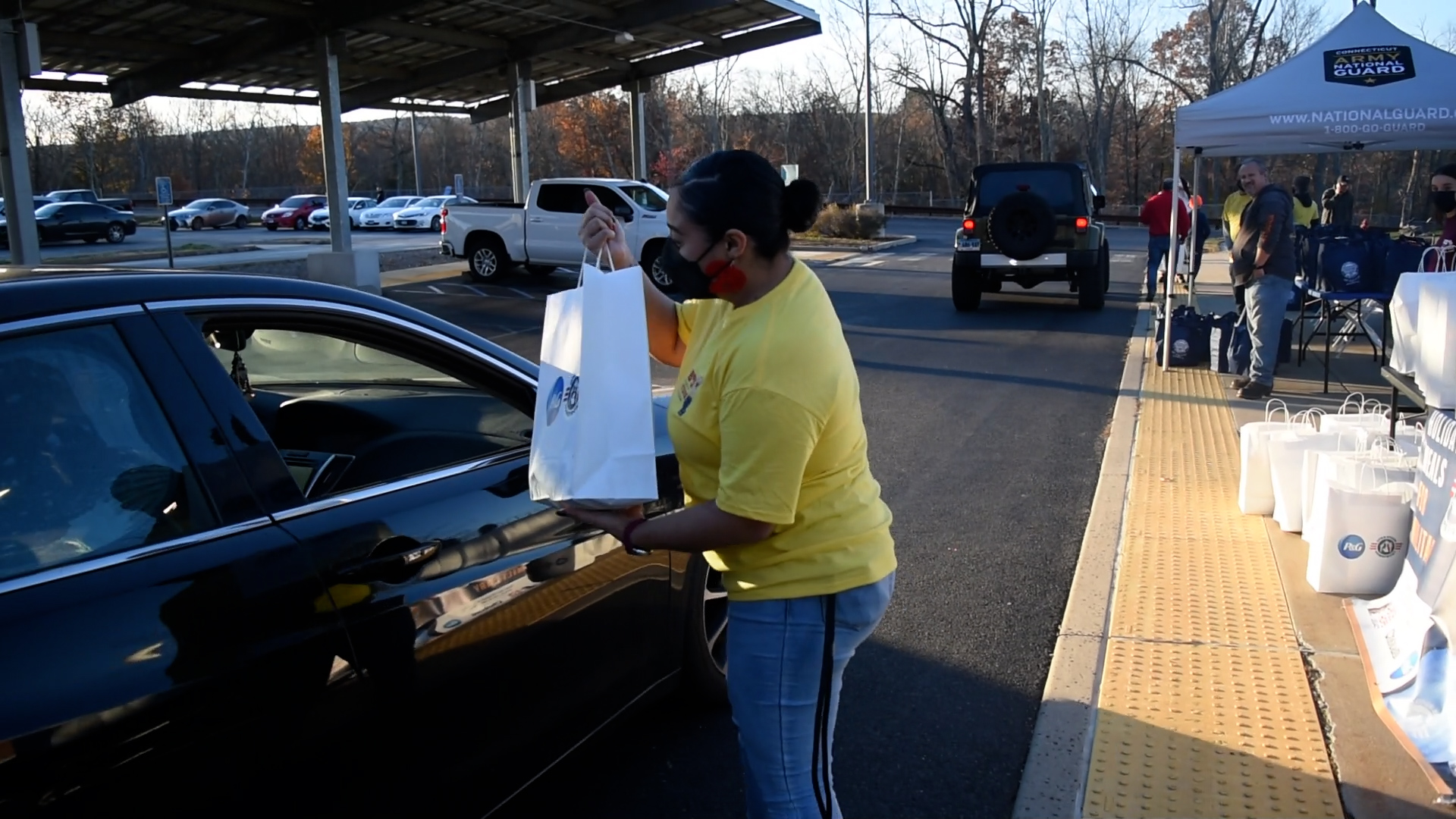 A Bob's employee presents a bag of cleaning supplies to a member of the military.