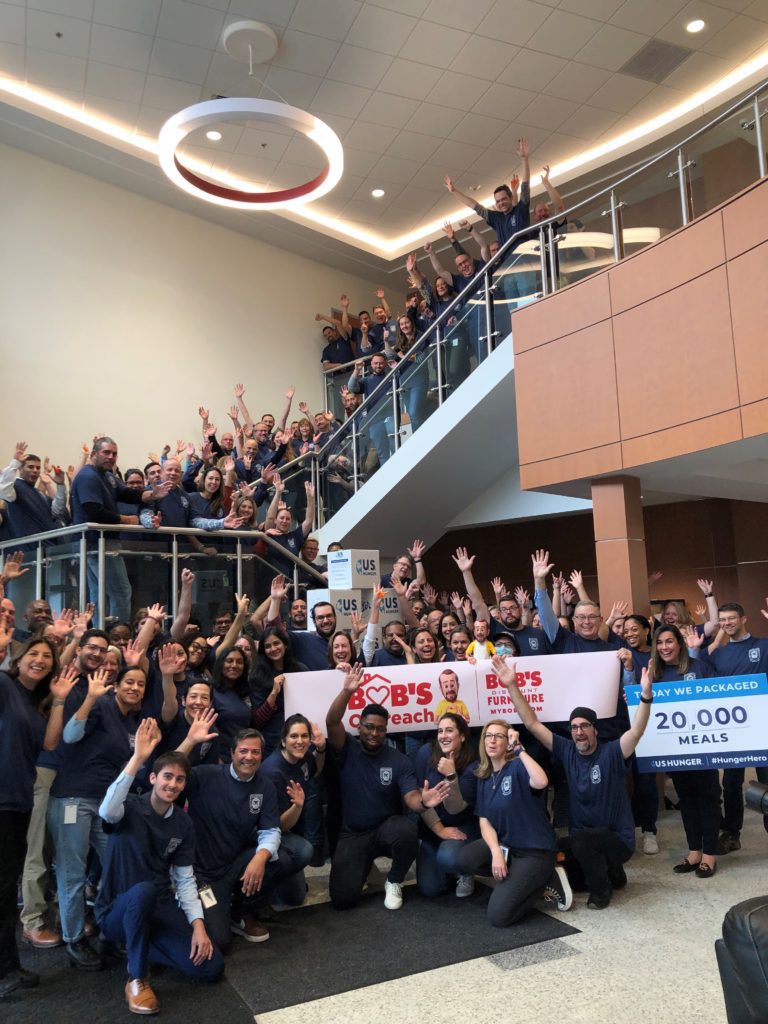 Employee celebrate after packing 20,000 meals